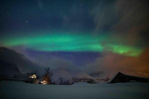特罗姆瑟Mountainside Lodge - Breivikeidet的天空中一片白雪 ⁇ 的极光