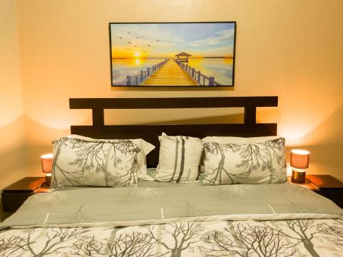 坎帕拉THEATRE OF DREAMS HOMES的一间卧室配有一张带码头画的床铺