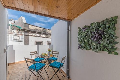 阿鲁卡斯Home2Book Charming Attic Arucas Center, Terrace的阳台上的桌椅,墙上挂着植物