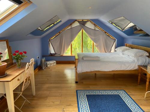 新港Ralph's Barn的一间卧室设有蓝色天花板、一张床和一张桌子