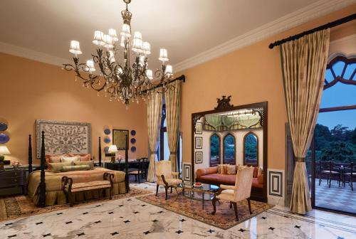 斋浦尔Rambagh Palace的一间卧室配有一张床和一个吊灯