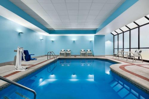 埃尔克顿纽瓦克 - 埃尔克顿啦奎塔套房酒店的一个带蓝色墙壁和窗户的游泳池