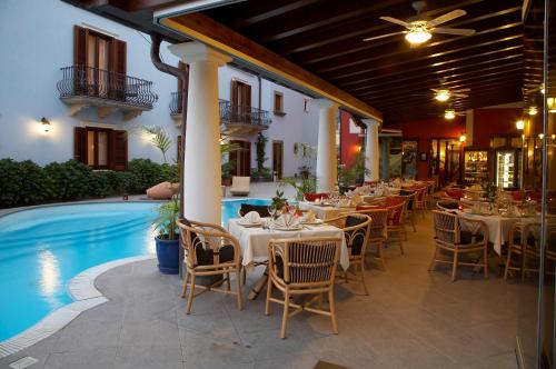利帕里阿奇杜卡大酒店的游泳池旁的餐厅配有桌椅