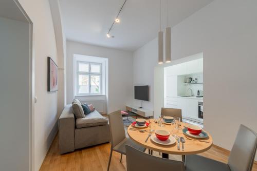 格拉茨Premium Apartments im Stadtzentrum的客厅配有桌子和沙发