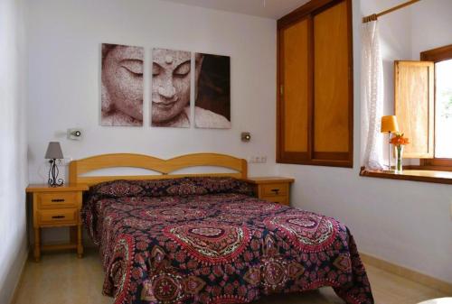 卡门港Casa Regla的卧室配有一张床,墙上挂有两张照片