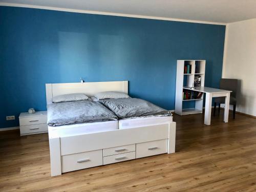 Ferienwohnung am Teutoburger Wald的卧室配有白色的床和蓝色的墙壁