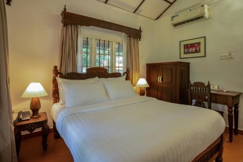 Fort KochiMAI HOUSE HERITAGE HOTEL的卧室设有一张白色大床和一扇窗户。