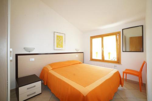 瓦达Appartamenti Manuela的一间卧室配有橙色的床和椅子