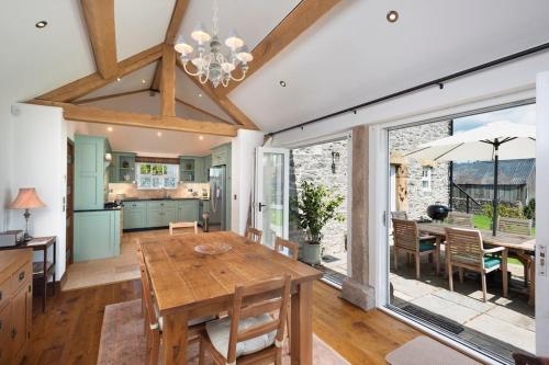 贝克韦尔Long Roods cottage的厨房以及带木桌的用餐室。