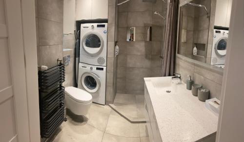 雷达Prestige Aquapark Apartments - Aquatower的浴室配有洗衣机、洗衣机和烘干机。
