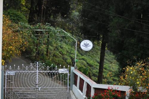 Kurseong11 Monteviot: Luxury homestay overlooking a tea estate的顶部有时钟的大门