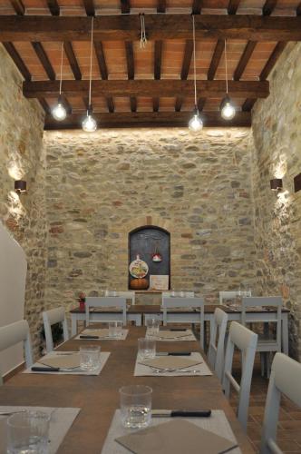 MontefortinoB&B Terra di Marca的一间设有桌椅和石墙的用餐室
