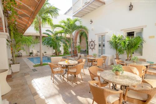 圣玛尔塔唐佩佩精品酒店的一个带桌椅的庭院和一个游泳池