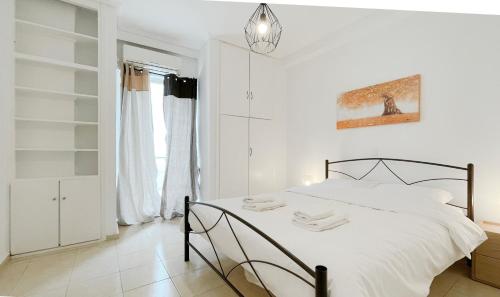 雅典Filis Sunny 80sqm apt in Viktoria的白色卧室配有一张床和吊灯