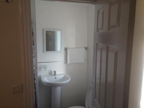北安普敦格拉夫顿客房酒店的白色的浴室设有水槽和卫生间。
