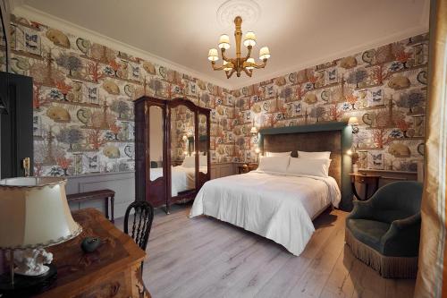 蒙托邦Castel Bois Marie, Maison d'hôtes的一间卧室配有一张床、镜子和吊灯