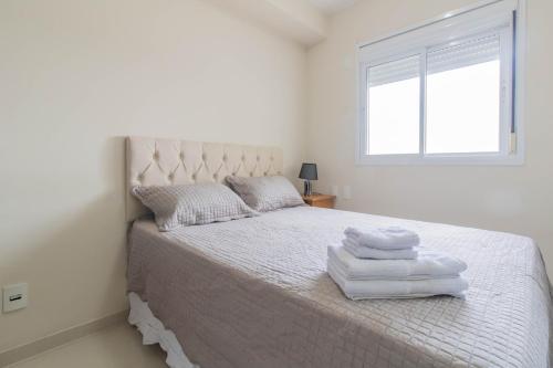 瓜鲁柳斯My Home Studio - GRU的白色卧室,配有带毛巾的床