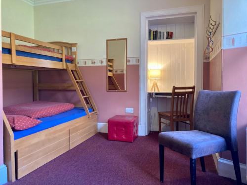 史宾桥Great Glen Hostel的一间卧室配有双层床、椅子和镜子