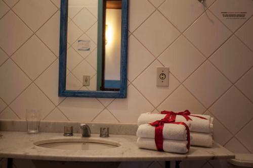 圣塞巴斯蒂昂-杜帕拉伊苏Pousada Nascentes da Fortaleza, antiga Água Azul的浴室水槽、毛巾和礼物