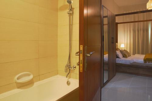 迪拜Calm&Cozy1BR- Dubai Silicon Oasis-15min-Dxb airpt的带浴缸和床的浴室