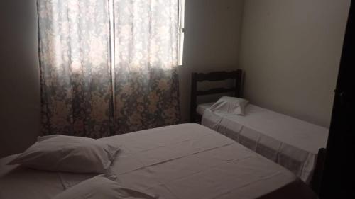蒙蒂斯克拉鲁斯Pousada Nova的小型客房 - 带2张床和窗户