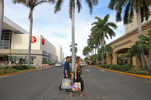 马那瓜马那瓜梅特罗森特洲际酒店的男人和女人带着购物袋走在街上