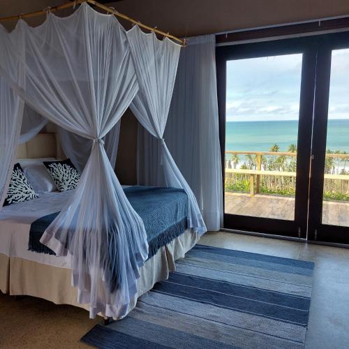 科鲁里皮Coco Pontall Bangalôs的一间卧室配有一张床,享有海景
