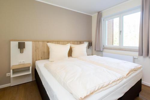 普劳西Hafendorf Haus 5 Apartment 2 Nr25的卧室配有一张大白色床和窗户