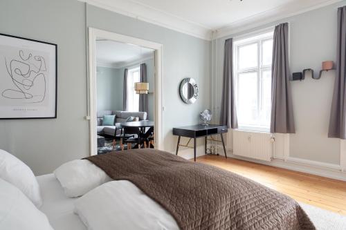 哥本哈根Spacious Scandinavian 3BR Flat in Vibrant Area的一间白色的卧室,配有床和客厅