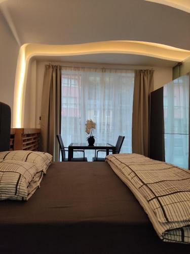 卢森堡CHEZ WL的一间卧室设有两张床和一张桌子及窗户