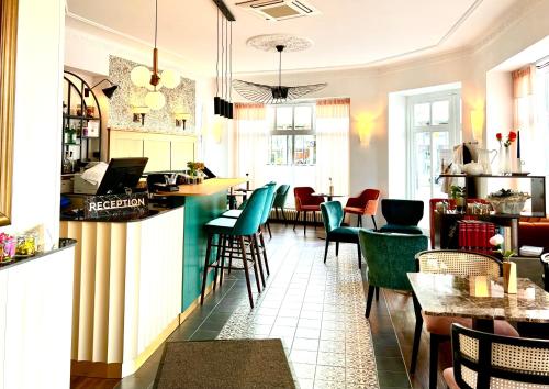 卡塞尔威廉选帝侯大街贝斯特韦斯特酒店的一间设有绿色椅子的餐厅和一间酒吧