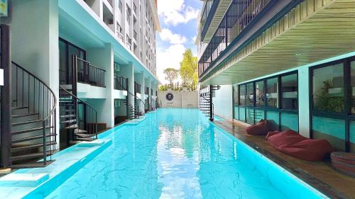 他朗Tour De Phuket Hotel - SHA Plus的一座建筑物中央的游泳池