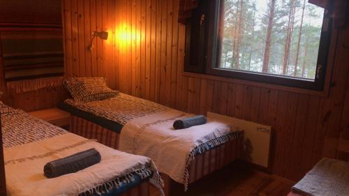 黑诺拉Villa Rapakivi的一间卧室设有两张床,其中设有窗户。