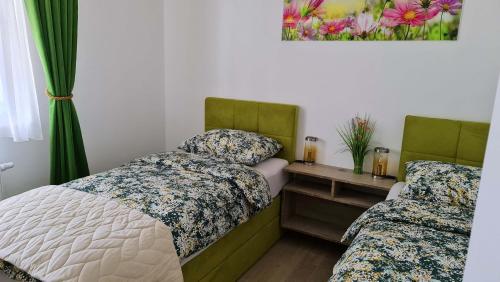 萨格勒布MINT ZAGREB的一间卧室配有两张床和一张鲜花桌