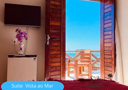 卡姆布库Pousada Sunrise Beach的客房设有电视、冰箱和窗户。