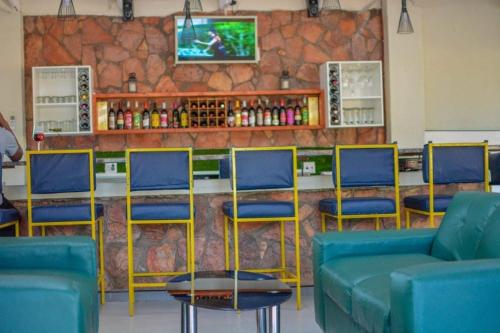 索赫燕杜Lamamie guest house的酒吧设有蓝色椅子和带电视的柜台。