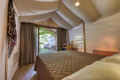 多尔梅莱托Camping Eden Glamping的一间卧室,卧室内配有一张大床