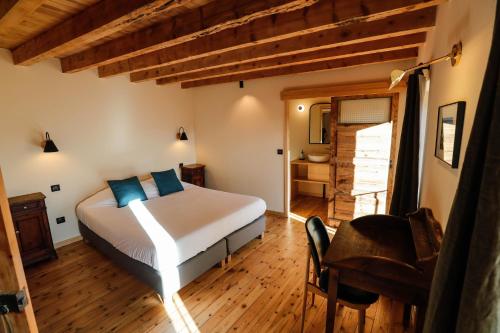 EnveitgDomaine Agricole Cotzé / Casa rural的一间卧室配有一张床、一张桌子和一把椅子