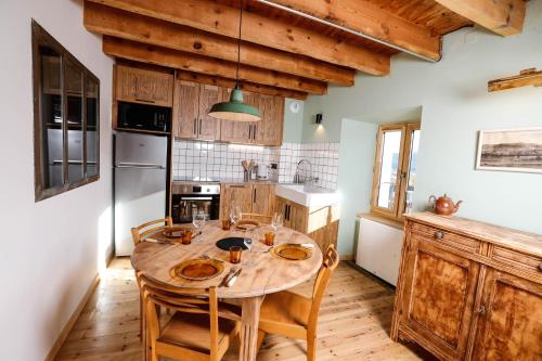 EnveitgDomaine Agricole Cotzé / Casa rural的厨房配有木桌和木橱柜。