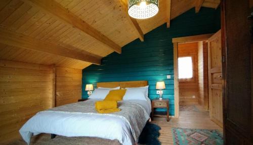 Solana de ávilaCasa rural El Bujo的一间卧室设有绿色的墙壁和一张带黄色枕头的床