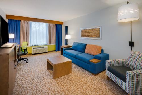 华盛顿堡Holiday Inn Express & Suites Ft. Washington - Philadelphia, an IHG Hotel的客厅配有蓝色的沙发和椅子