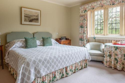 斯特明斯特牛顿Plumber Manor Hotel的一间卧室配有一张床、一把椅子和窗户。