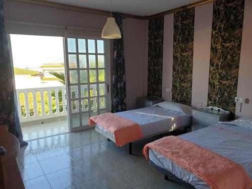 格拉纳迪利亚德亚沃纳Casa Rural Fayna的一间卧室设有两张床和大窗户