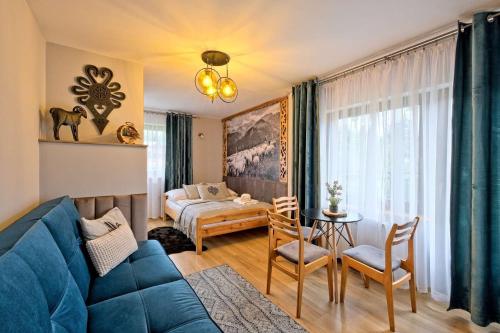 扎科帕内Willa u Baranów的一间带蓝色沙发的客厅和一间卧室