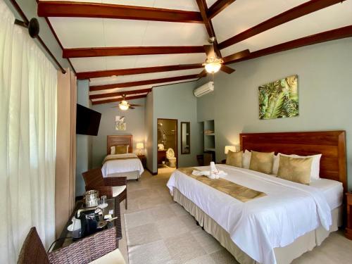 曼努埃尔安东尼奥Hotel Playa Espadilla & Gardens的酒店客房设有两张床和电视。
