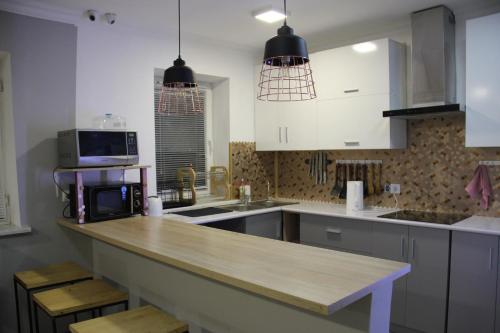 阿拉木图Hostel 211A的厨房配有白色橱柜和木制台面