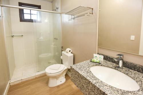 格拉玛多Pousada Três Pinheiros的浴室配有卫生间、盥洗盆和淋浴。