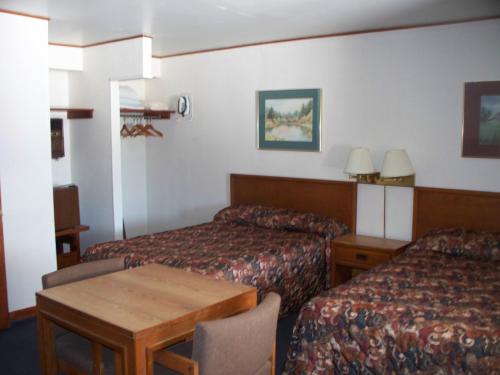 戴维斯Alpine Lodge的酒店客房设有两张床和一张桌子。