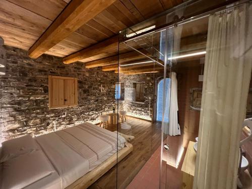 莱什Mrizi i Zanave Agroturizëm的一间卧室设有一张床和一个玻璃淋浴间