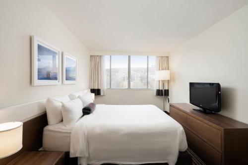 蒙特利尔Hôtel 2170 Lincoln Downtown Montreal的一间酒店客房,配有一张床和一台电视